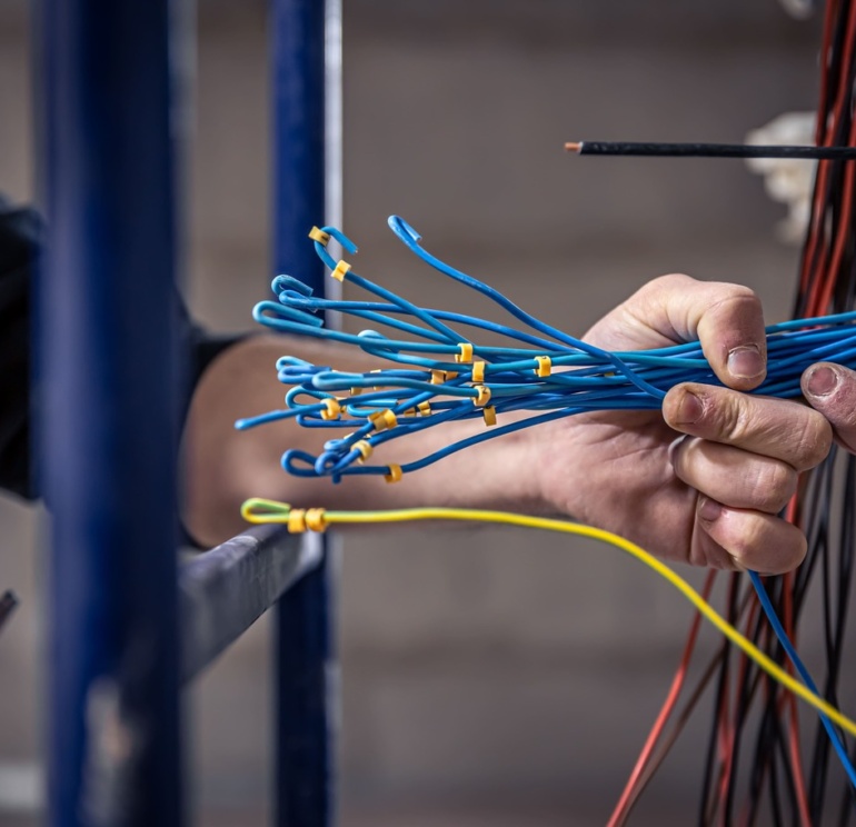 male electrician works switchboard with electrical connecting cable 1